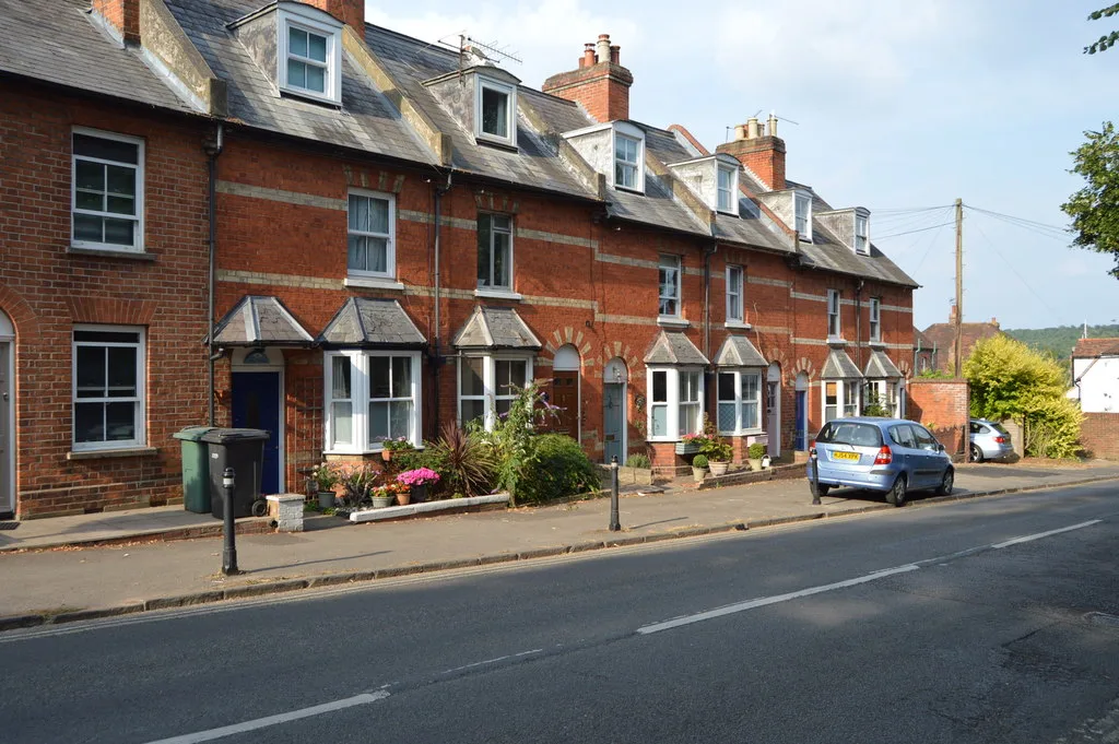 A terraced row on Gravel Hill, Henley-on-Thames, with a green recycling bin out on the pavement